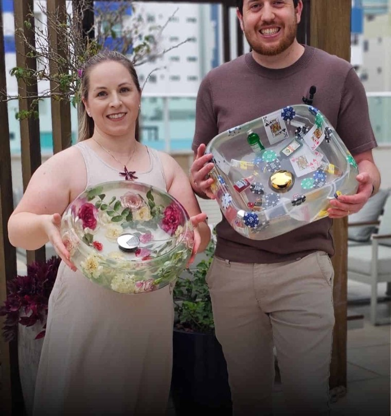 Ana y Junior sostienen dos lavabos de resina terminados