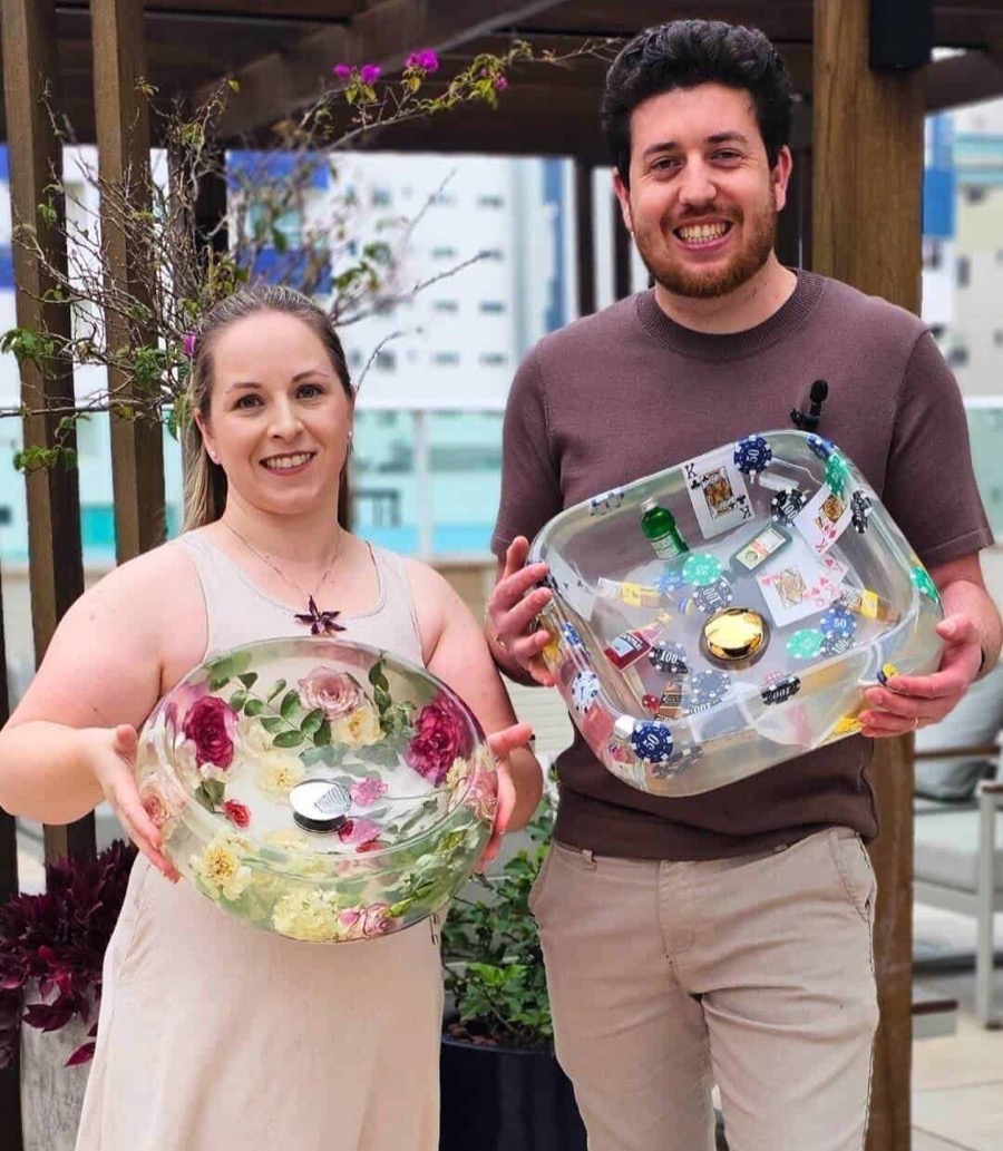 Ana y Junior sostienen dos lavabos de resina terminados
